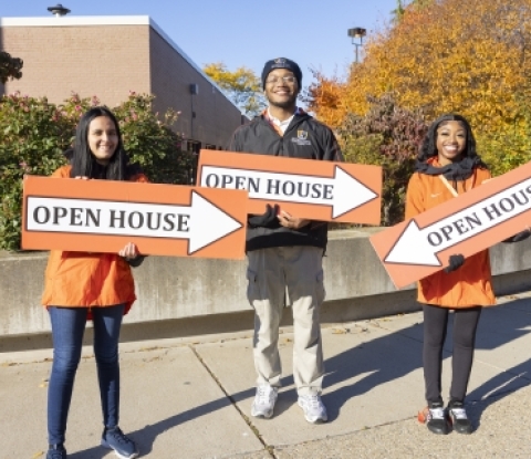 Three students holding signs